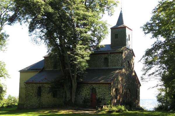 Die Blasiuskapelle auf dem Blasiusberg, umgeben von hohen Bäumen.