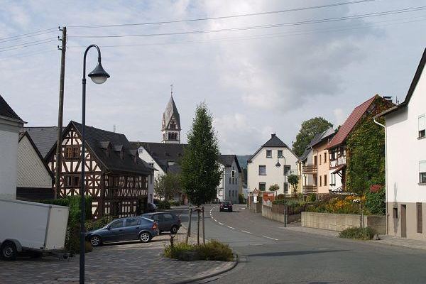 Dorfstraße mit Fachwerkhaus und Kirchturm